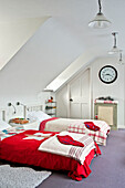 Zwillingsbetten mit Patchwork-Bettdecken und Weihnachtsstrümpfen in einem Haus in Crantock, Cornwall, England, UK