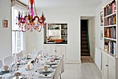 Beaded glass chandelier above dining table with service hatch in Penzance family home Cornwall England UK