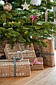 Gift wrapped presents under Christmas tree in Wadebridge home, North Cornwall, UK