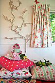 Light decoration and assorted cushions with floral patterned curtains in caravan
