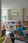 Schreibtisch und Stuhl mit Ledersofa im Doppelwohnzimmer eines Familienhauses in East Grinstead, West Sussex, England