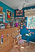 Artwork and ornaments on wooden chest at window in East Grinstead child's room West Sussex England UK