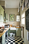 Hellgrüne Einbauküche mit Wandtafel und karierten Bodenfliesen in einem Haus in Stamford Lincolnshire England UK