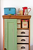 Toy cars and storage tins on kitchen dresser in Cambridge cottage England UK