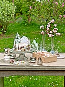Easter cake on stand with cut flowers on garden table in Sussex England UK