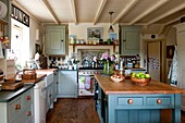 Einbauküche mit pastellgrünen Schränken in der Küche eines Landhauses in Edworth, Bedfordshire, England UK