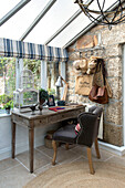 Brown chair at wooden desk with hatrack in window of Penzance farmhouse Cornwall England UK