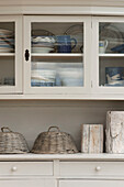 Chinaware and cake covers in glass fronted kitchen dresser Penzance farmhouse Cornwall England UK