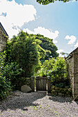 Wooden gate and gravel path in grounds of Helston farmhouse Cornwall UK