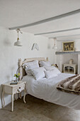 Fur rug on white double bed in Marazion beach house Cornwall UK