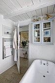 Glasschrank über freistehender Badewanne in einem Badezimmer in Marazion, Cornwall UK