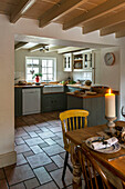 Lit candle on table in open plan kitchen with tiled floor and dishwasher St Erth Cornwall UK