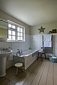 White tiled bathroom with painted floorboards in St Erth bathroom Cornwall UK