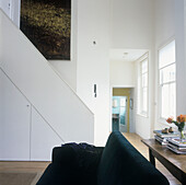 Modern white living room with staircase and high ceilings