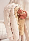 Woman holding wool and cotton blankets