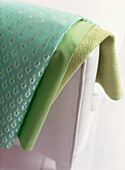 Detail of vibrant green fabrics draped over a chair