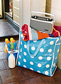 Bright blue plastic spotty beach bag with radio beach towel and skittles