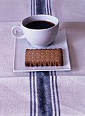 Coffee cup with biscuit on saucer