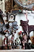 Mantlepiece detail with an assortment of quirky objects a row of fairy dolls loving put together from vintage fabrics and trimmings and embellished with old buttons and other market finds