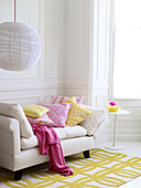 Blanket and cushions on daybed with pendant and rug