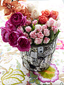 Cut flowers in tiled vase on floral tablecloth
