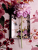 Single stem Dahlia flower on floral chinaware