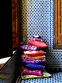 Helle Kissen und geometrische Kacheln in einem marokkanischen Riad in Nordafrika