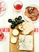 Blue cheese and sliced bread with grapes and salami on tabletop Spain