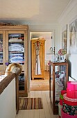 Hallway landing storage in glass-fronted dressers, Cranbrook home, Kent, England, UK