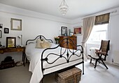 Metallgefertigtes Bettgestell und antike Möbel im weißen Schlafzimmer eines Hauses in Tenterden, Kent, England, UK