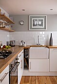 Wooden shelving in light grey and white kitchen in St Leonards home, East Sussex, England, UK