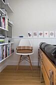 Folded blankets on chair with artwork and books