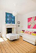 White leather ottoman and colourful artwork in living room of Manchester family home, England, UK