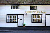 Weißes Schindelhaus mit schwarzem Anstrich und Schriftzug in Egerton, Kent, England, UK