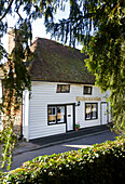 Weißes Schindelhaus mit schwarzem Anstrich und Schriftzug in Egerton, Kent, England, UK