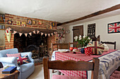 Light blue armchair beside brick fireplace in Egerton cottage, Kent, England, UK