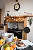 Recipe book and fruit on worktop of Tenterden kitchen with recessed range oven, Kent, England, UK