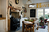 Recipe book and ingredients with pan on butchers block in Tenterden kitchen, Kent, England, UK