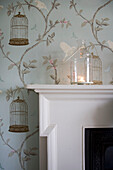 Mantlepiece and wall detail with lit candle in Tenterden home, Kent, England, UK