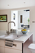 Fruit bowl on sink surround of island unit in modern home Bath Somerset, England, UK