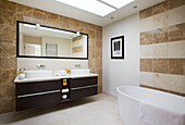 Double basin in brown tiled bathroom of modern home Bath Somerset, England, UK