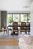 Wicker chairs at dining table in contemporary farmhouse, Nuthurst, West Sussex, England, UK