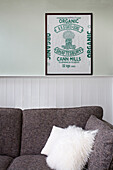 Weißes Straußenfederkissen auf grauem Sofa in hellgrünem Wohnzimmer mit Vintage-Kunstwerk Deal home Kent England UK