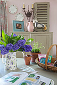 Purple cut flowers with gardening trug on kitchen table in High Halden farmhouse Kent England UK
