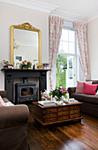 Woodburning stove and wooden coffee table drawer unit in living room of Kilndown home Cranbrook Kent England UK