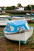 Blaues Boot am Strand von Emsworth, Hampshire, England UK