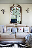 Vintage-Spiegel über cremefarbenem Sofa im Wohnzimmer einer viktorianischen Villa Kent England UK