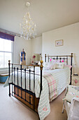 Schmiedeeisernes Doppelbett mit karierter Decke in viktorianischer Villa, Kent, England, UK