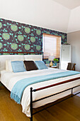 Doppelbett mit Blümchentapete in einem Strandhaus auf Hayling Island in Hampshire England UK