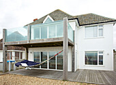 Glass balcony with terrace at exterior of detached Hayling Island beach house Hampshire English UK